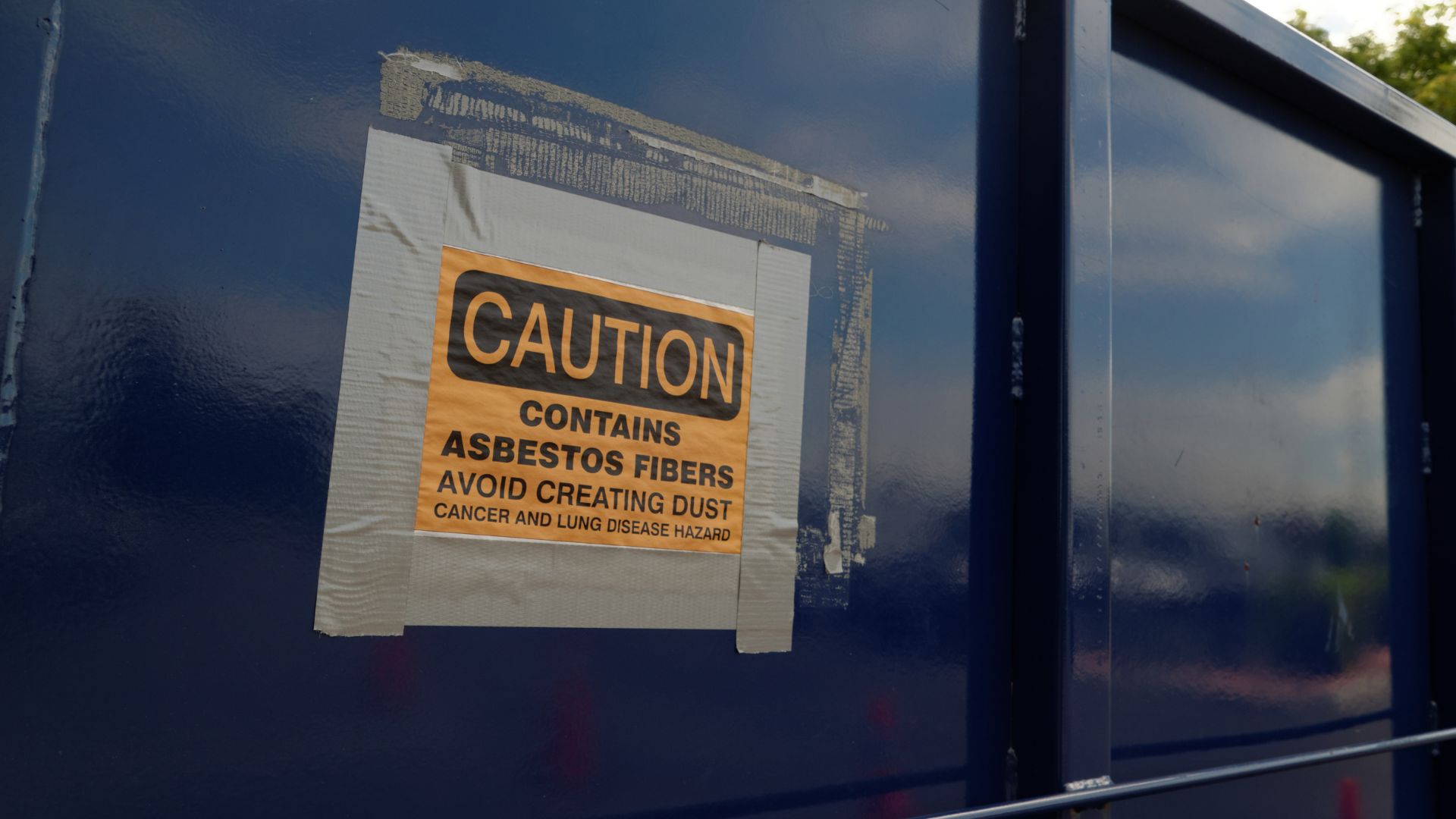 A caution sign posted on the side of a blue trailer