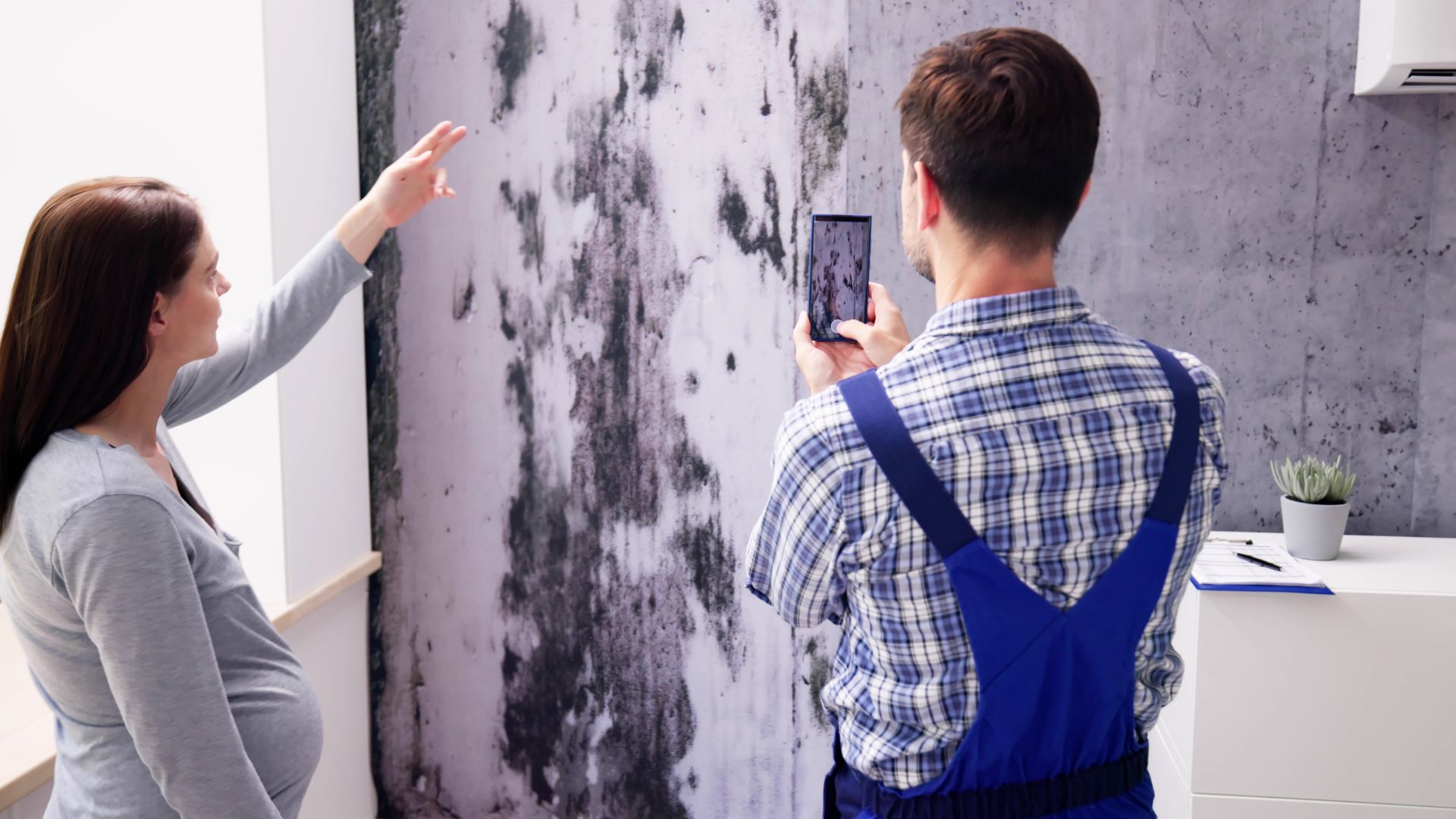 A man taking a picture of a woman with a cell phone